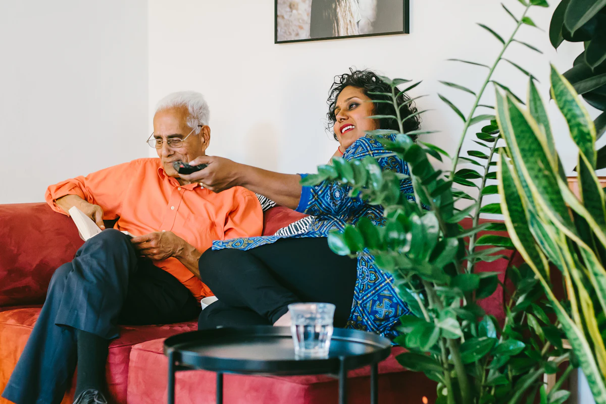 A caregiver chatting with an older man in his living room