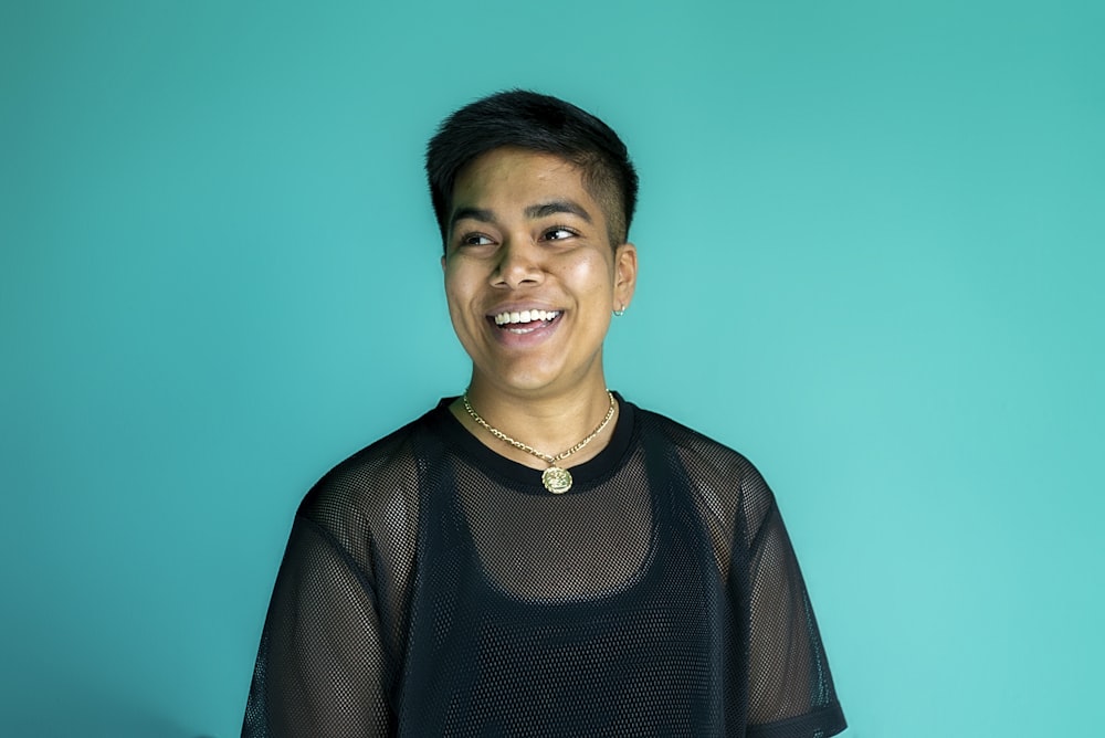 a man in a black shirt smiles at the camera