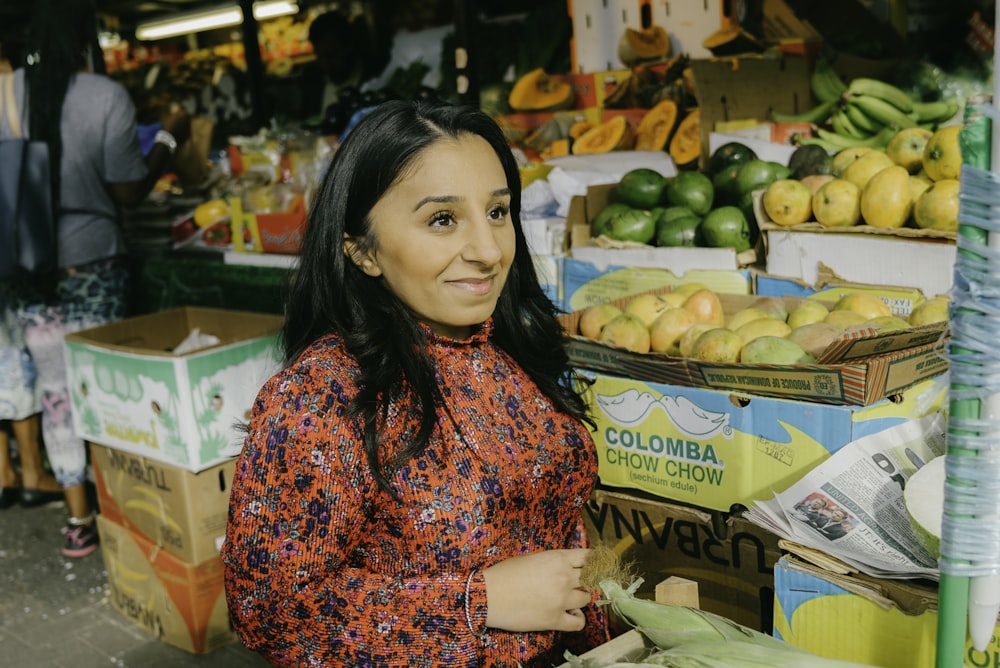 a woman standing in front of a fruit stand