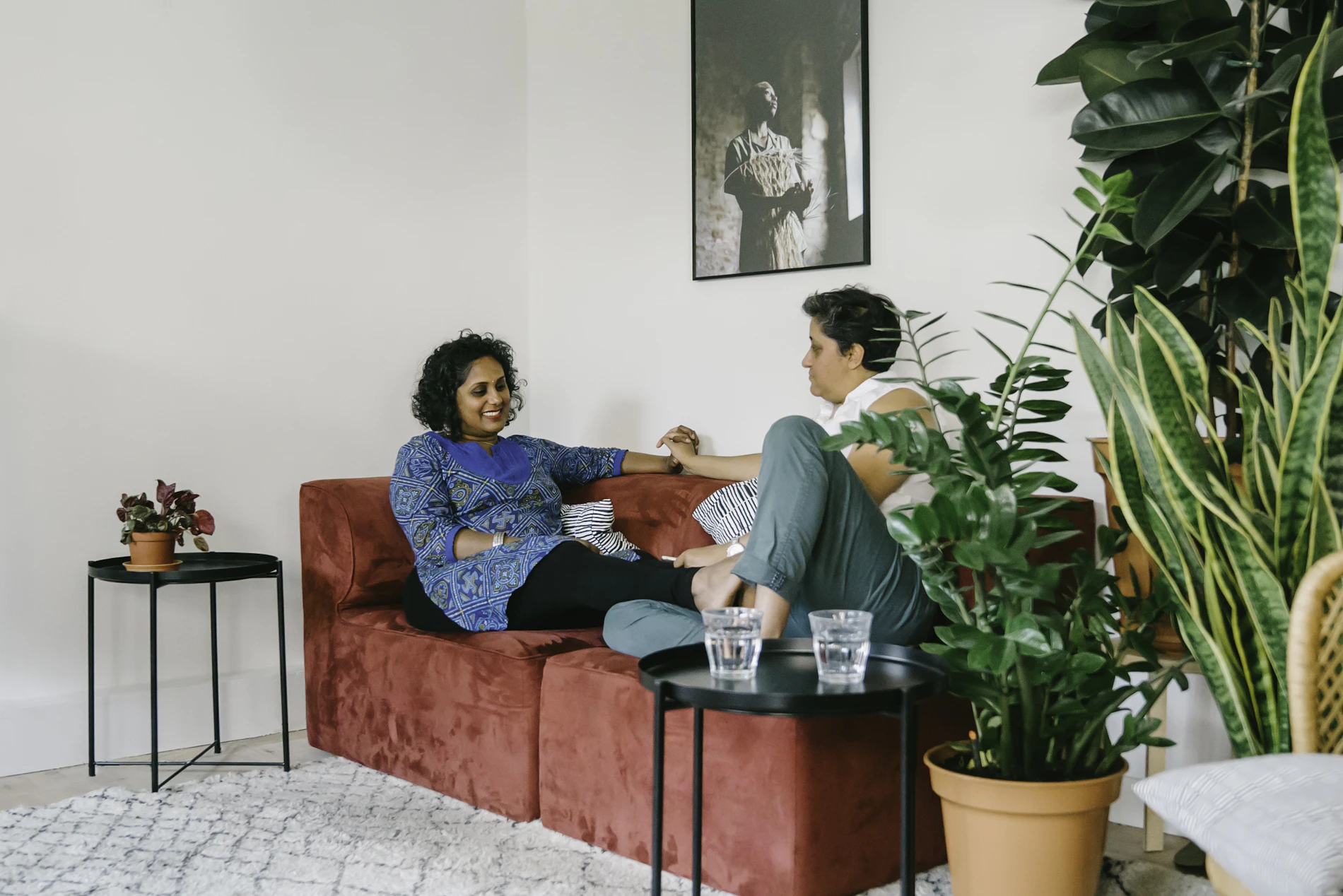 Begeleider in gesprek met een cliënt in haar eigen woonkamer
