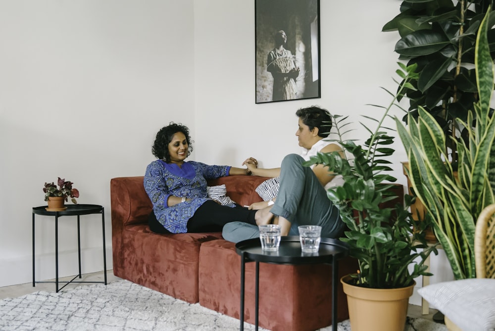 a woman sitting on a couch talking to another woman