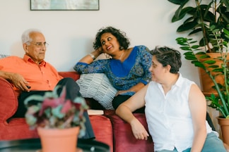 a woman sitting on top of a red couch next to a man