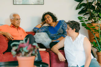 a woman sitting on top of a red couch next to a man