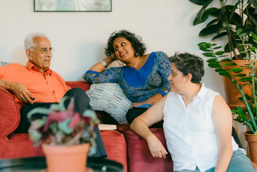 a woman sitting on top of a red couch next to a man