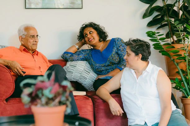a woman sitting on top of a red couch next to a man