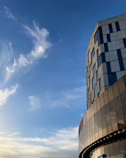 A commercial building framed by steel beams with a clear blue sky backdrop.