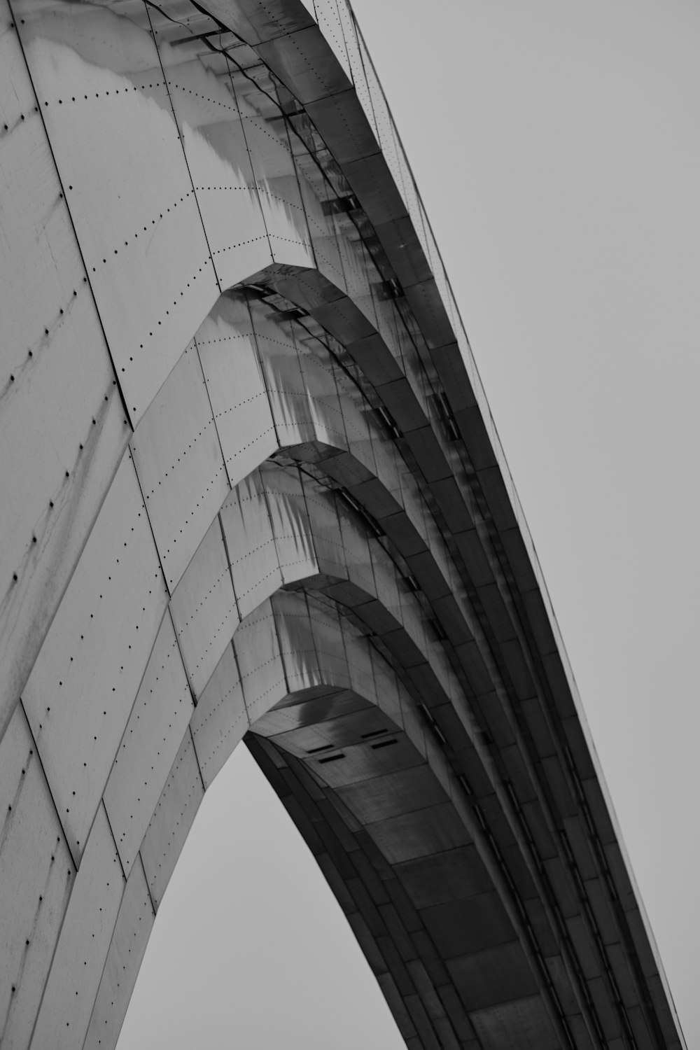 a black and white photo of a curved bridge