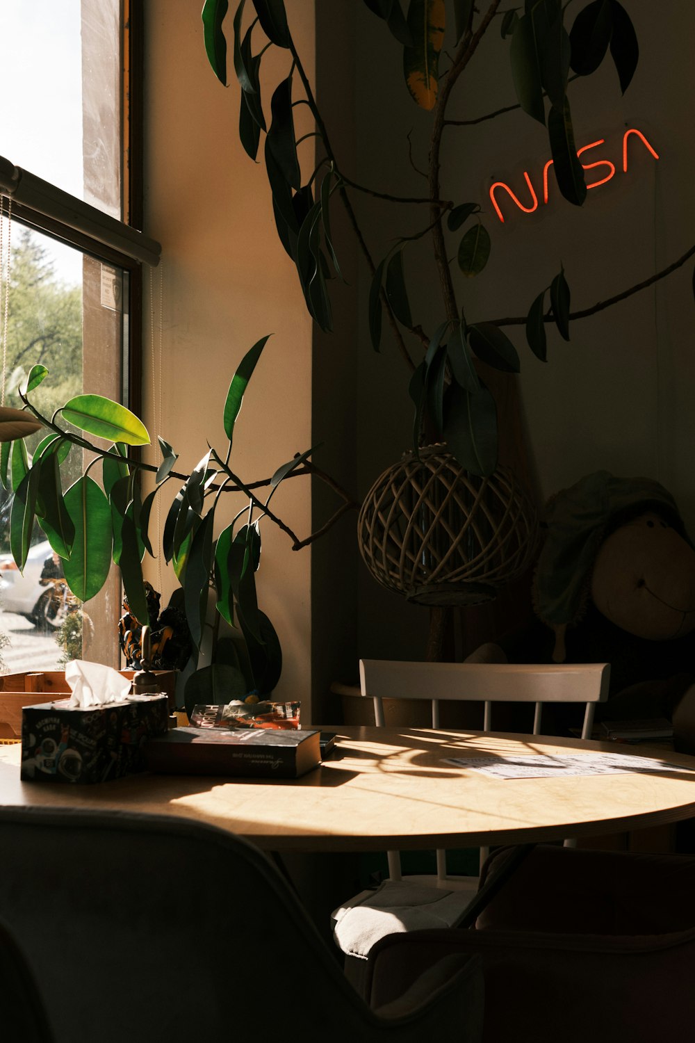 a wooden table topped with a potted plant next to a window