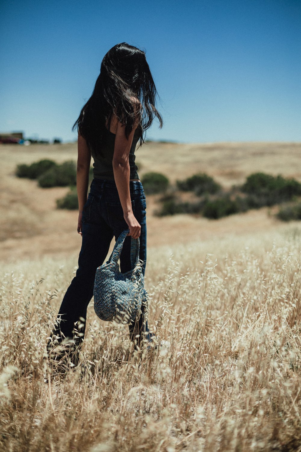 a woman standing in a field of tall grass