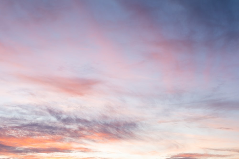 a plane flying in the sky at sunset