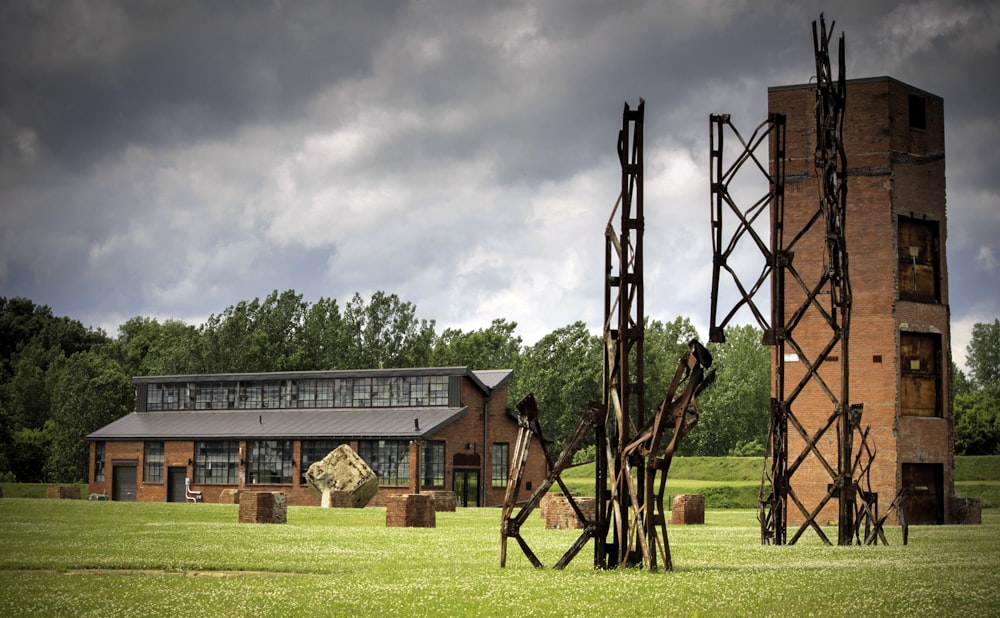 a couple of tall metal sculptures sitting on top of a lush green field