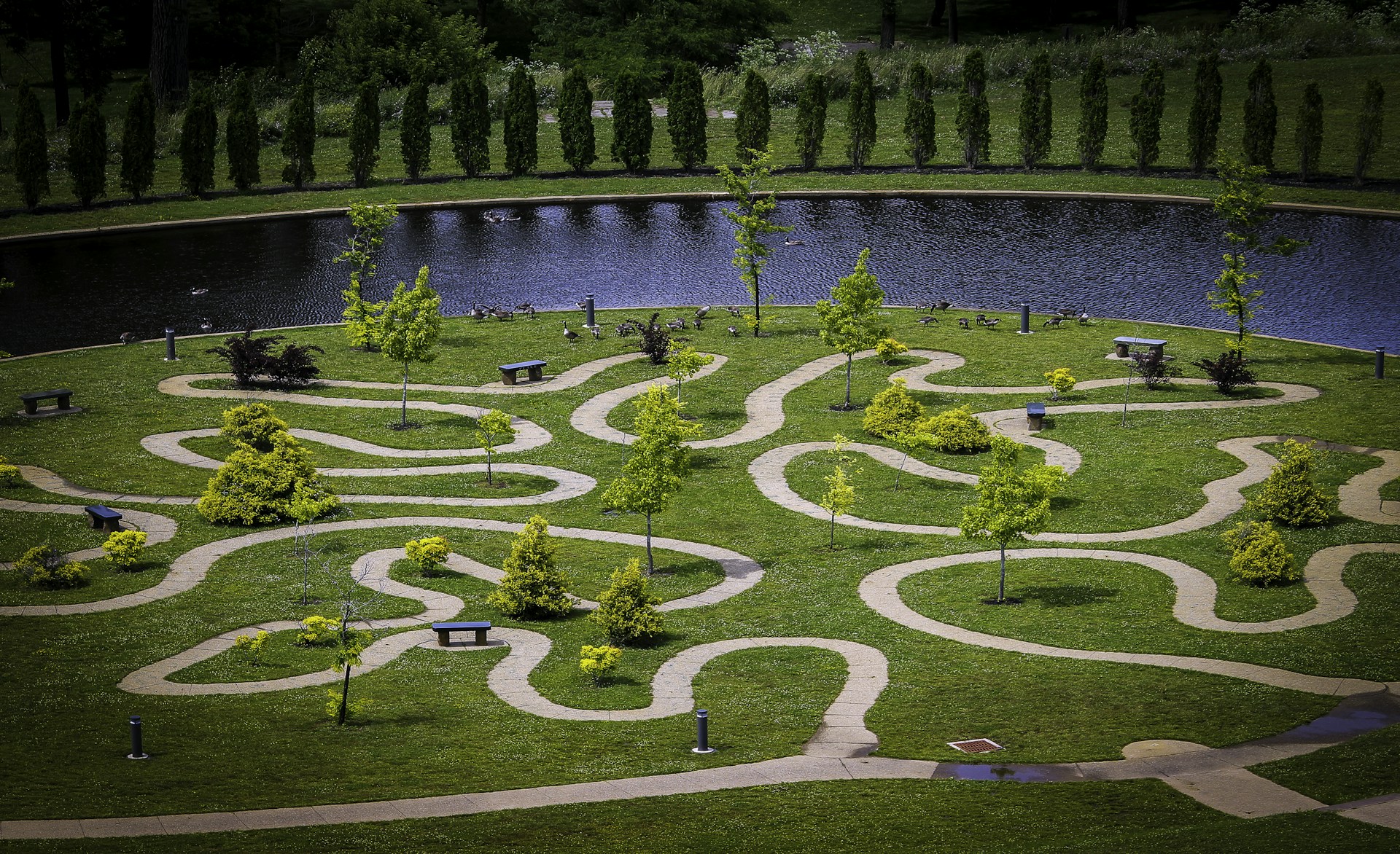 an aerial view of a park with a river and trees