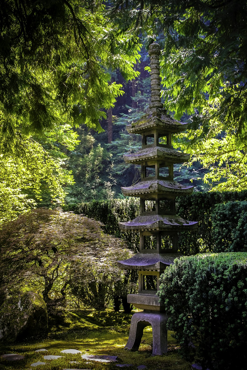 a stone pagoda in the middle of a garden