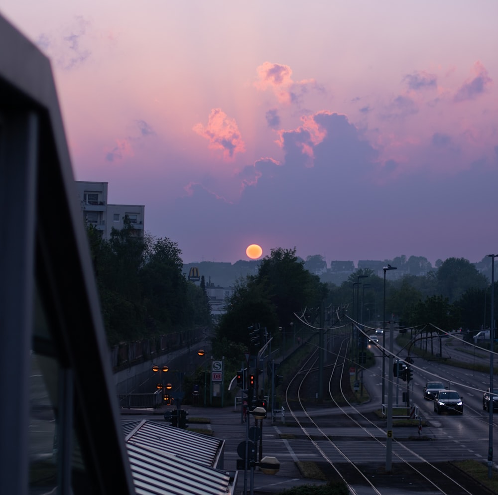 the sun is setting over a train track
