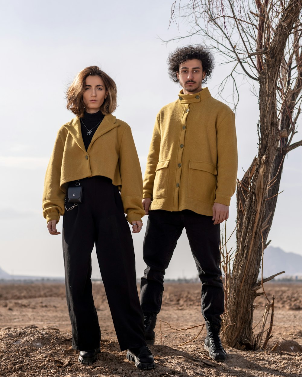 a couple of people standing next to a tree