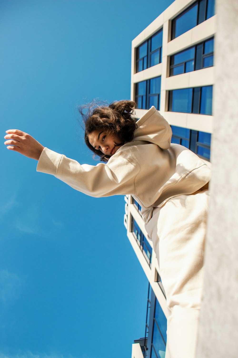 a woman in a white coat is flying through the air