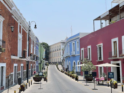 A street of coloured colonial facades with tables outside, Puebla