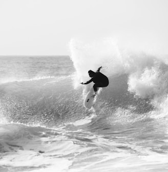 a man riding a wave on top of a surfboard