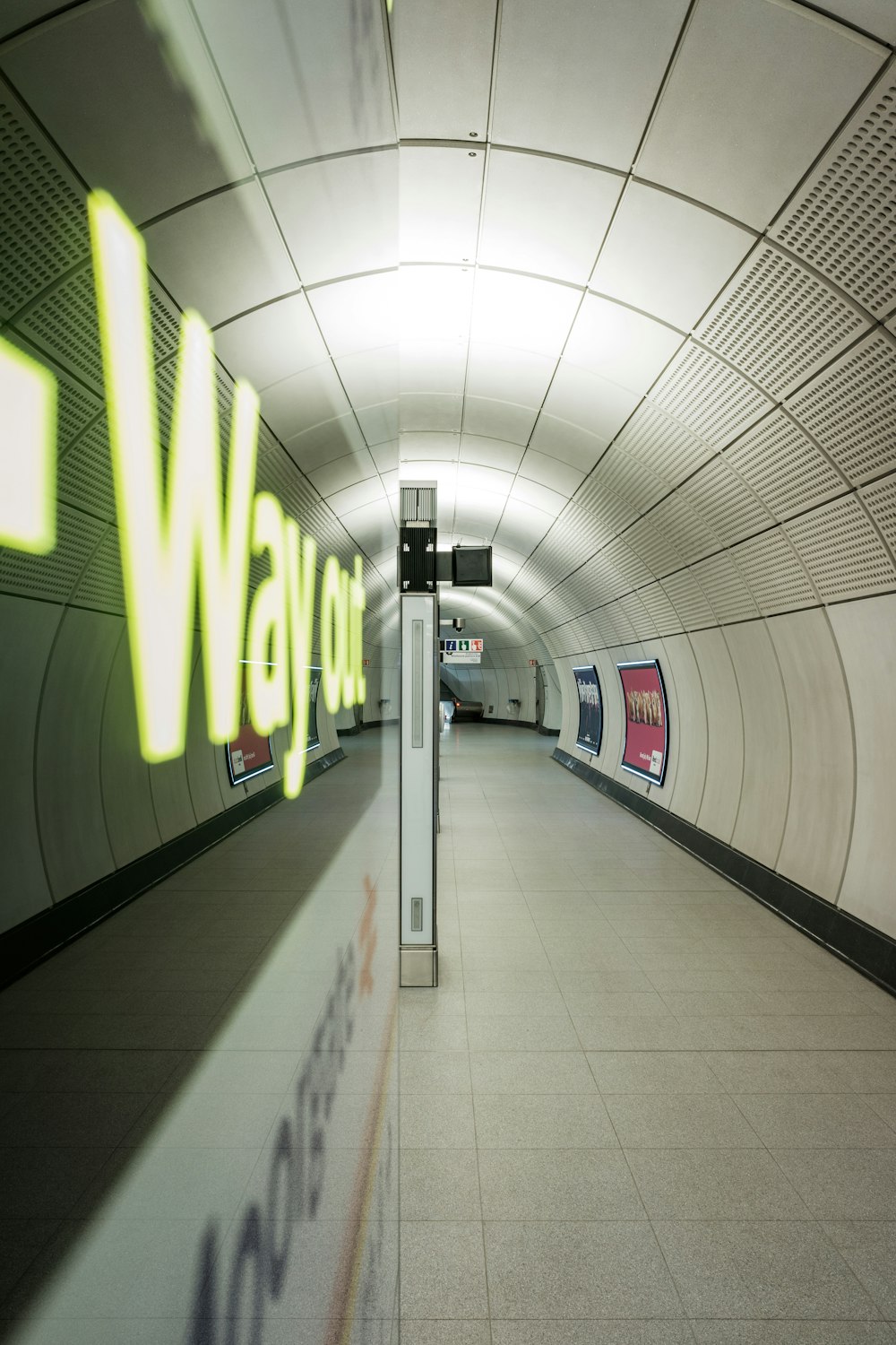 a subway tunnel with a sign on the wall