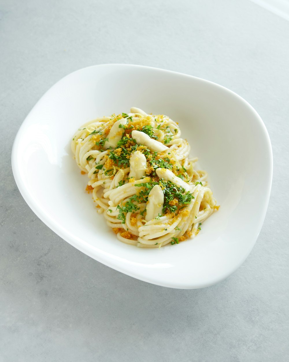 a white bowl filled with pasta and sauce