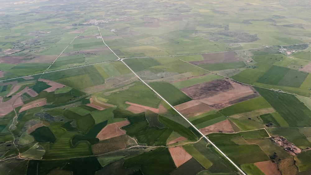 an aerial view of a green field with lots of trees