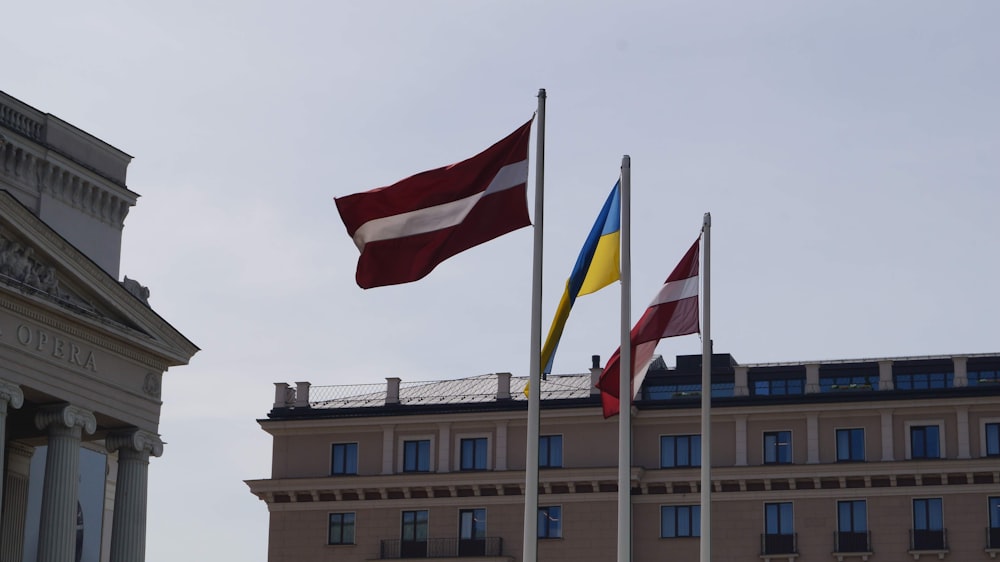 a group of flags flying in front of a building