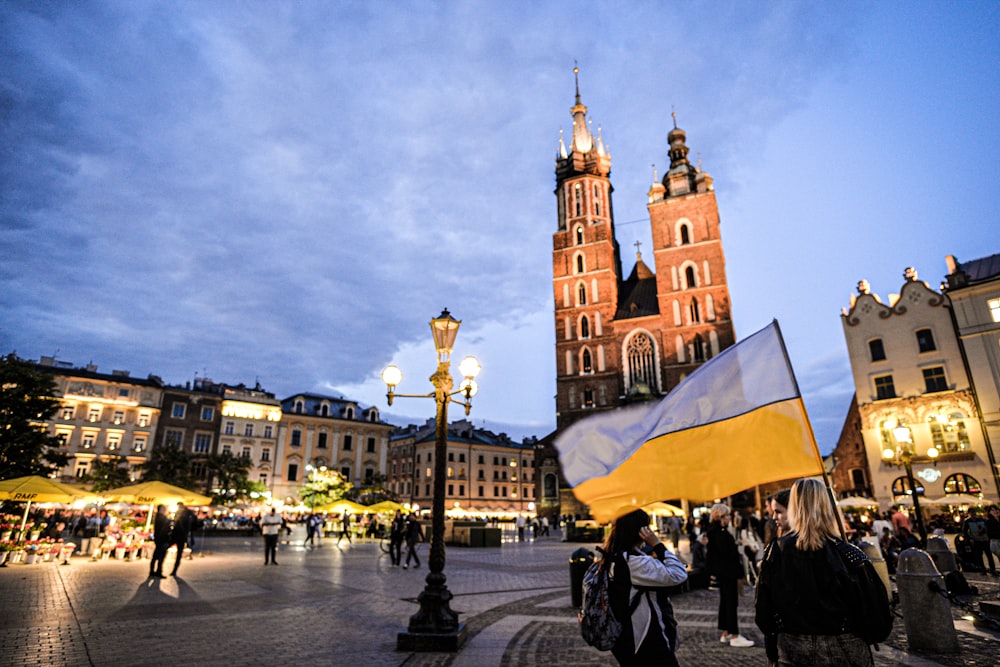 a crowd of people walking around a town square