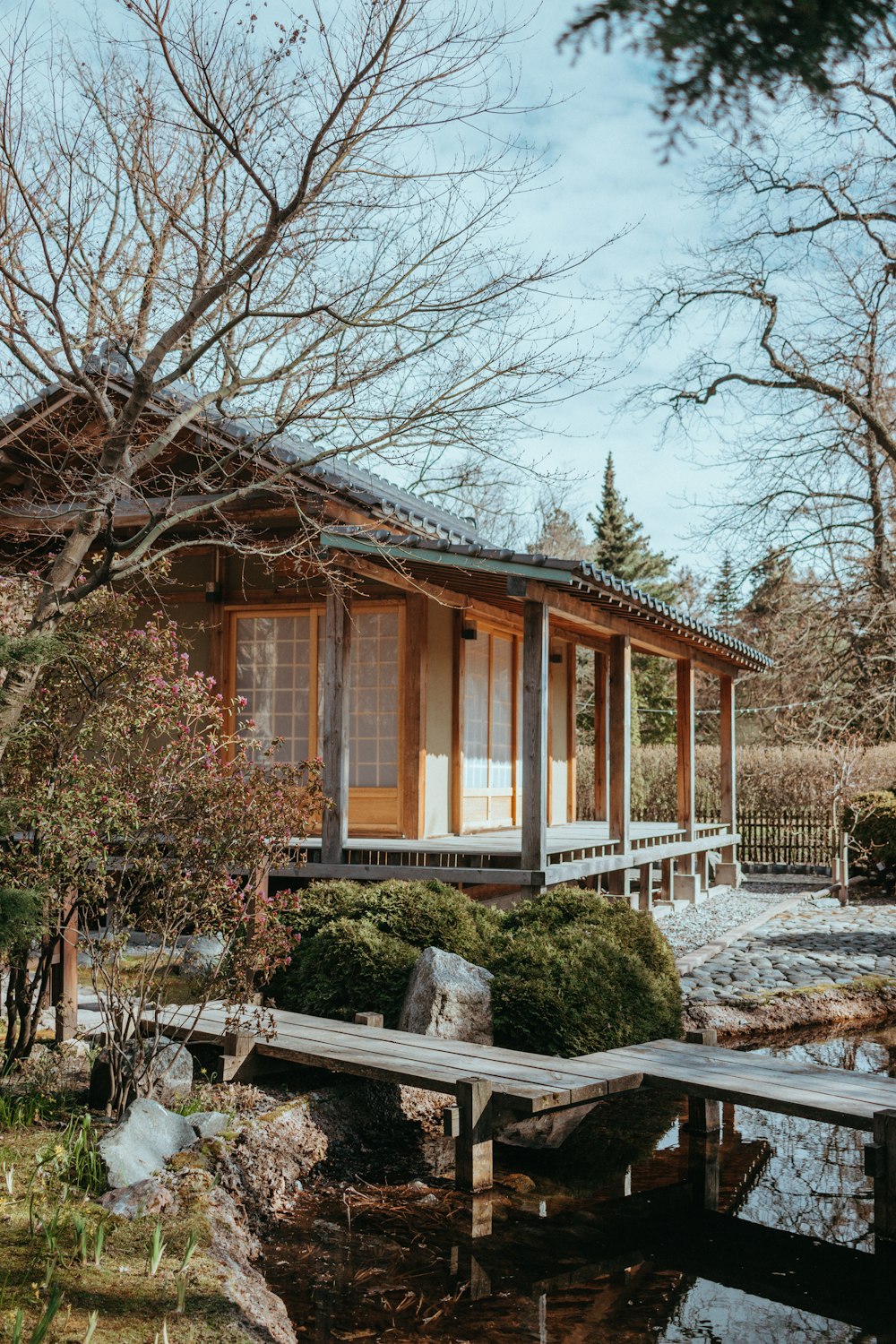 a small wooden house sitting next to a pond