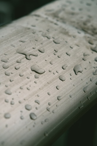 Close-up of a sleek fridge water filter cartridge with droplets of water on its surface.