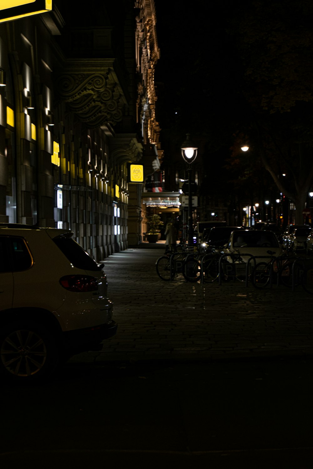 um carro estacionado ao lado de uma rua à noite