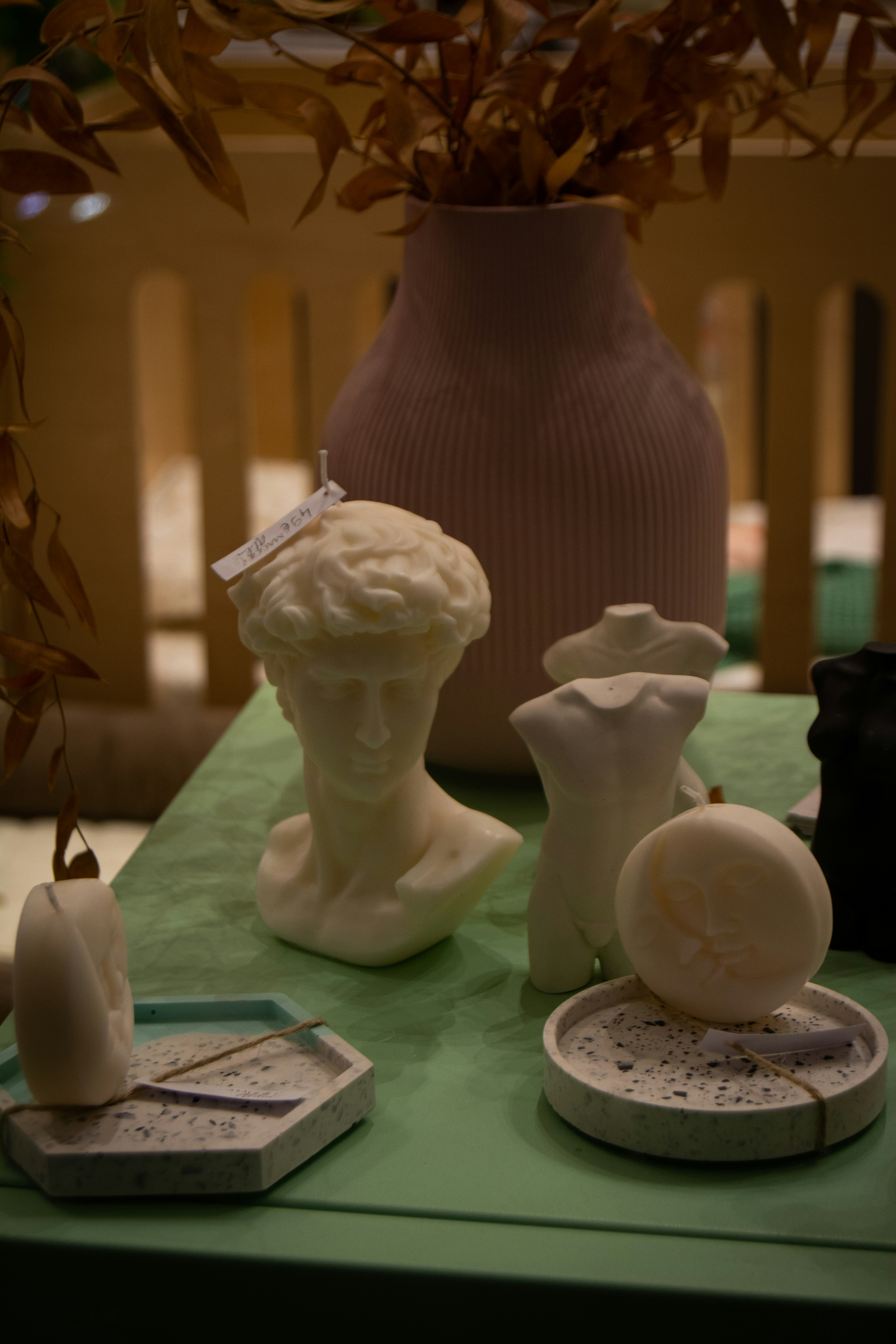 a green table topped with a vase filled with flowers