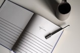 a notebook with a pen on top of it