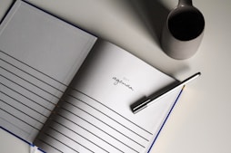 a notebook with a pen on top of it