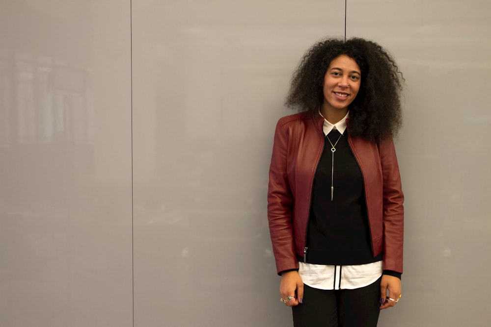 a woman standing in front of a gray wall