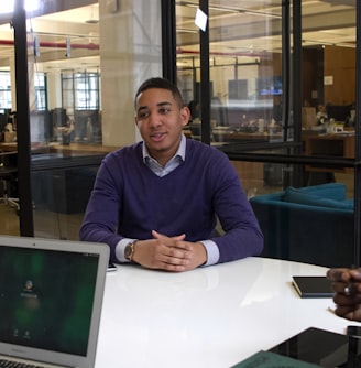 a man sitting at a table with a laptop