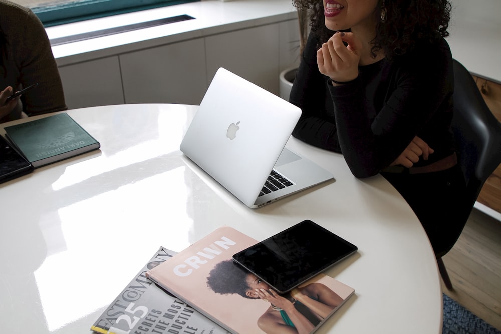 a woman sitting at a table with a laptop