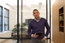 a man standing in an office holding a tablet