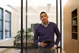 a man standing in an office holding a tablet