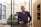 a man standing in an office holding a tablet