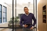 a man standing in an office holding a tablet