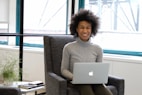 a woman sitting in a chair with a laptop