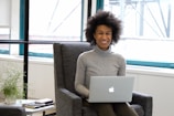 a woman sitting in a chair with a laptop