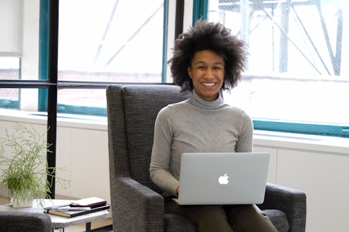 a woman sitting in a chair with a laptop
