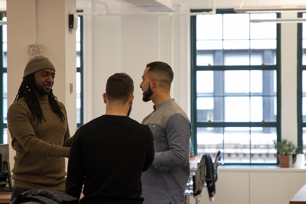 a group of men standing around each other in a room