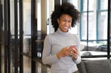 a woman standing in a lobby holding a cell phone