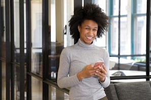 a woman standing in a lobby holding a cell phone