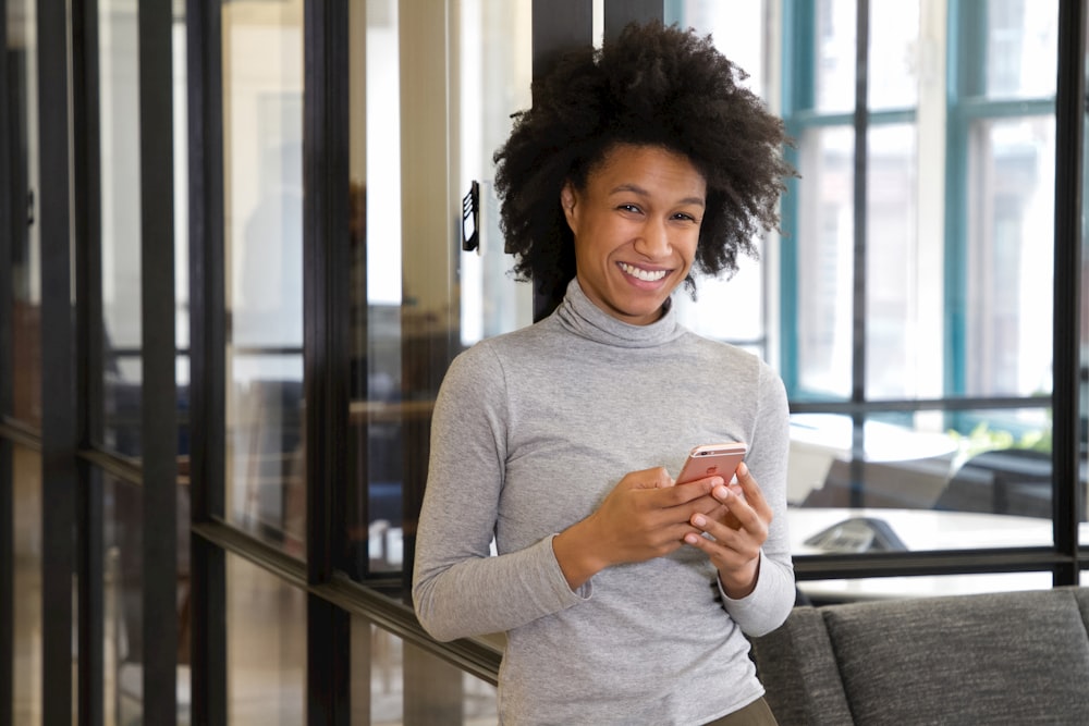 a woman standing in a lobby holding a cell phone