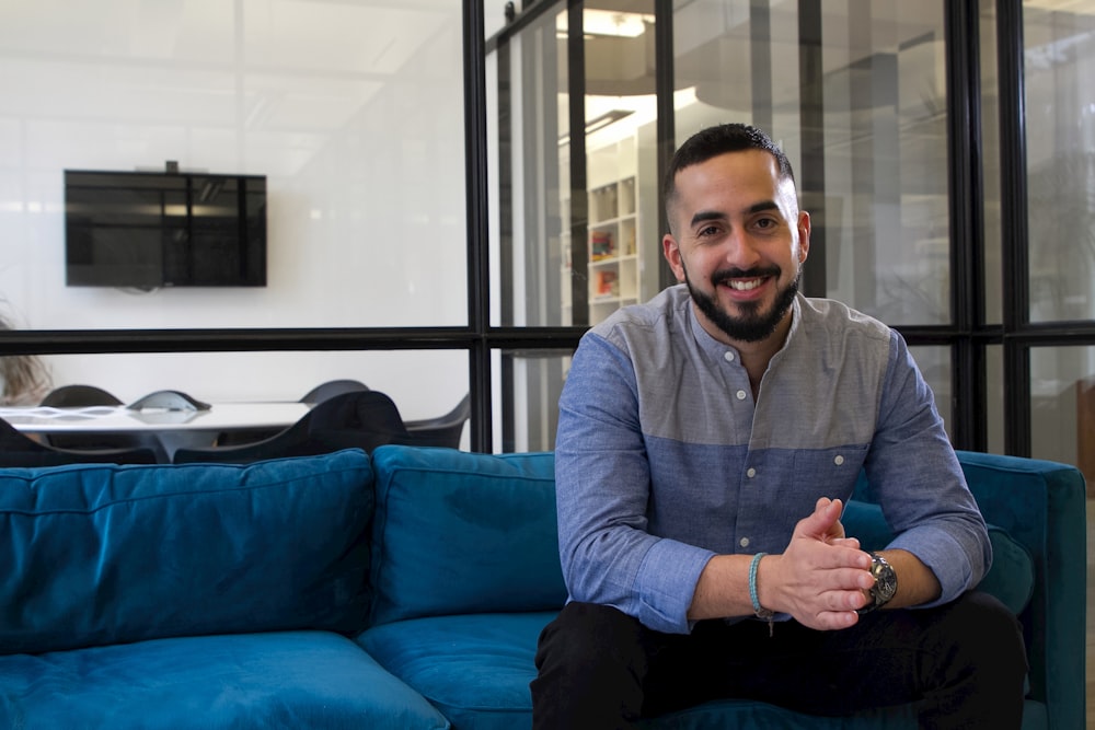 a man sitting on top of a blue couch