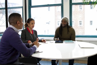 a group of people sitting around a white table
