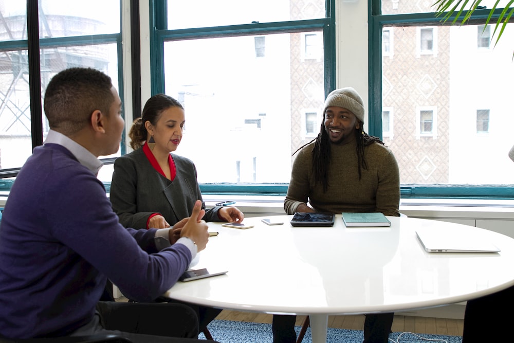 a group of people sitting around a white table